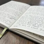 open journal resting on a wooden bench